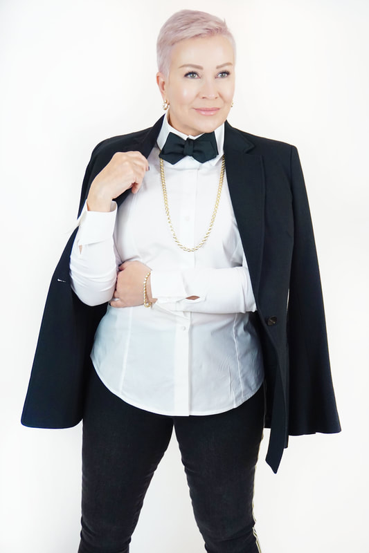 Mrs. Stafford in a black blazer, pants & bowtie, with a white button-up and Gumuchian gold jewelry Picture