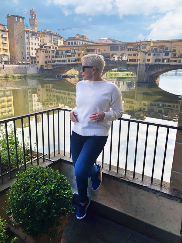 Mrs. Stafford standing on balcony over River Arno in Italy